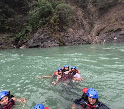 Friends enjoying a refreshing swim in the river during rafting