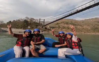 Friends enjoying Marine Drive to Rishikesh rafting under a suspension bridge