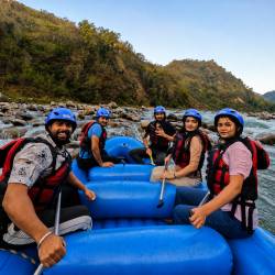 Group of visitors enjoying river rafting among the mountains in Rishikesh