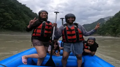Two girls posing for a photo while standing on a river rafting raft