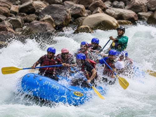 Tourists are enjoying thrilling Golf Course rapids in Rishikesh rafting during a 16 km
