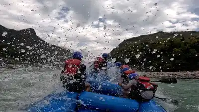 Rafters hitting a big wave at Three Blind Mice rapid during river rafting in Rishikesh.